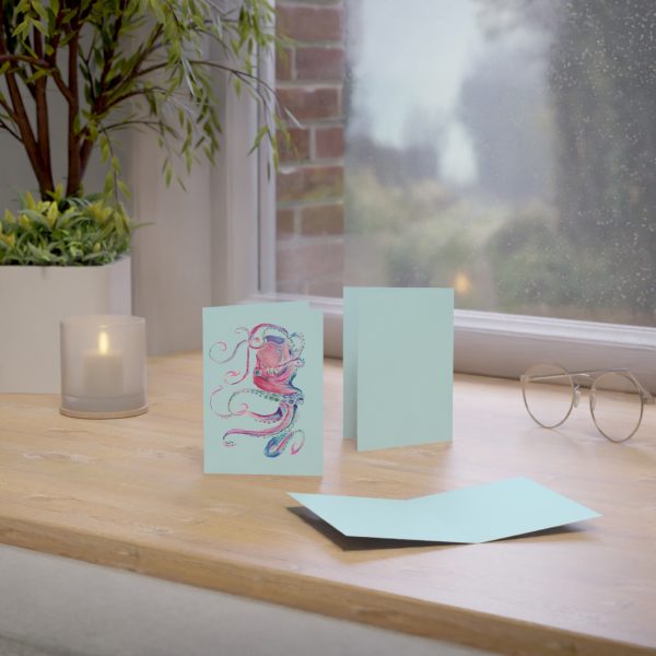 Octopus greeting cards on wooden table near window